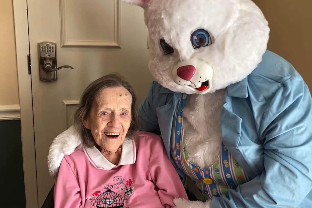 A smiling resident with the Easter bunny at Lavender Hills Front Royal Campus in Front Royal, Virginia