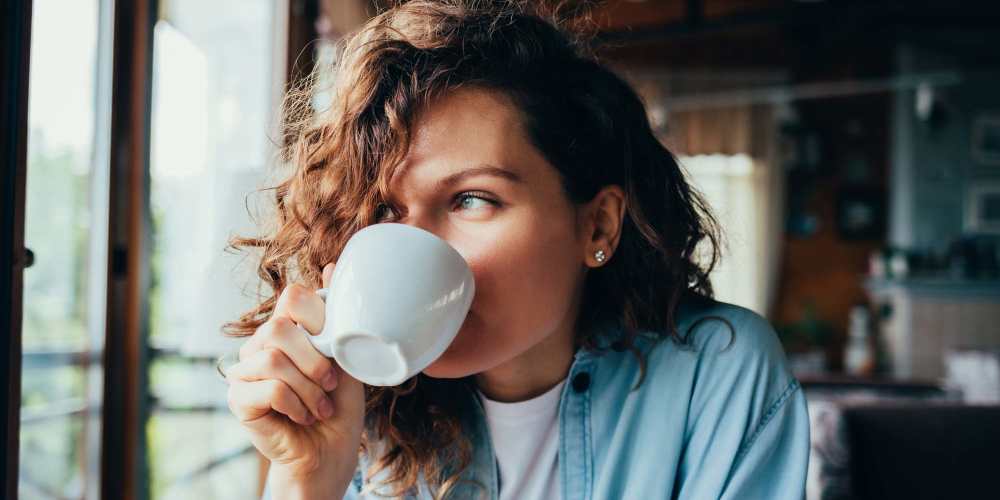 Woman having a cup of coffee near West Edge in Lynchburg, Virginia