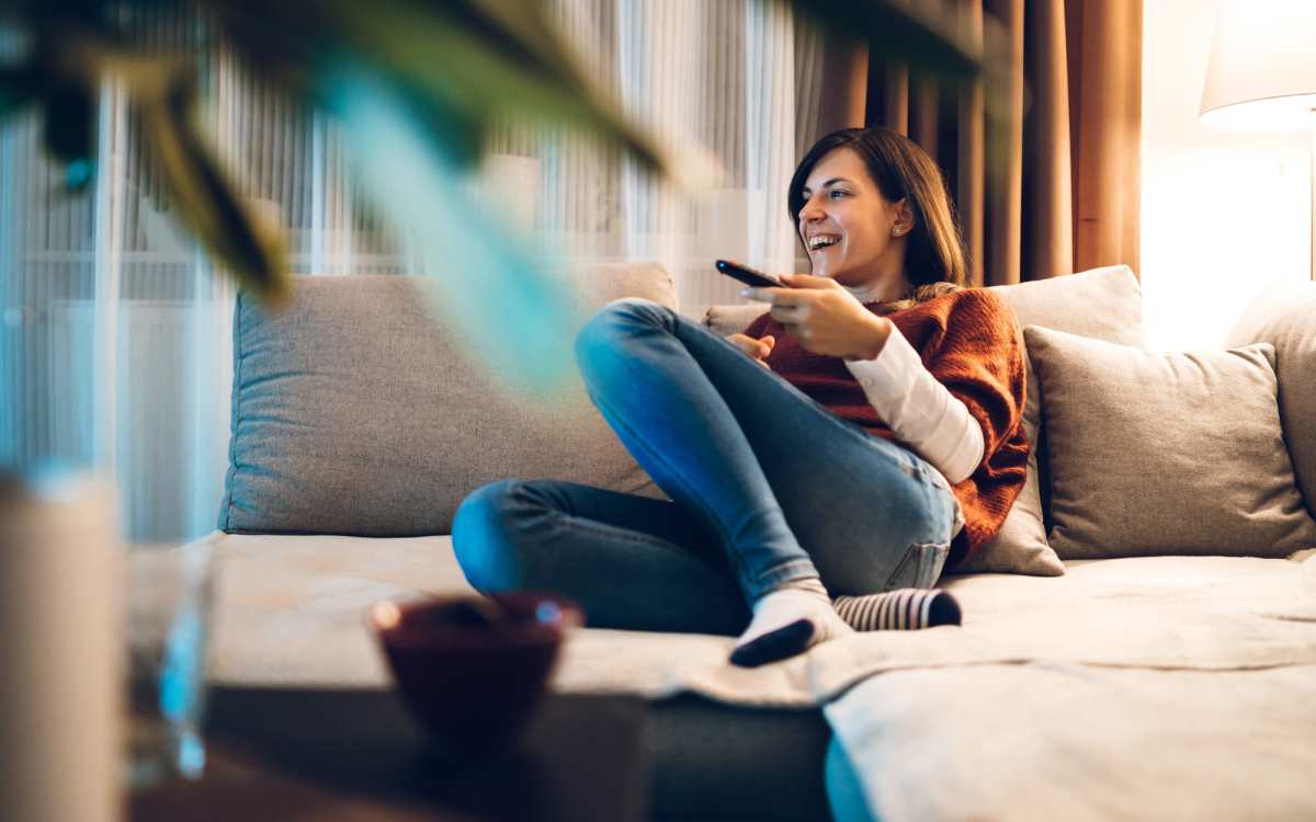 Resident relaxing in living room sofa at Ember Ridge Apartments in Pensacola,Florida
