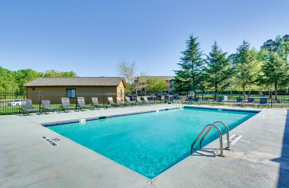 Swimming pool with a large sundeck for sunbathing at Woodbrook Apartment Homes in Monroe, North Carolina