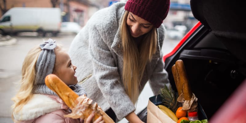 A mother and her daughter putting the grocery in the car  near Miramar Milcon in San Diego, California