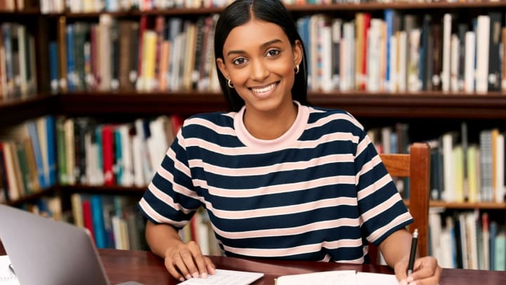 A young female student studying in a library at college 