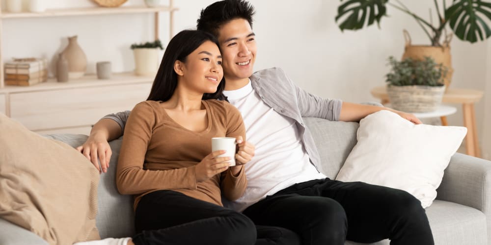 A couple sitting on their couch together at Mason Drive Apartments in Columbus, Georgia