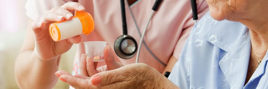 Resident managing their medications with their caretaker at Retirement Ranch in Clovis, New Mexico