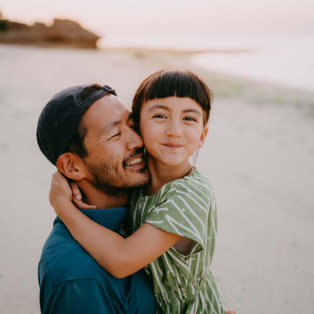 Man holding a child on the beach near Coral Wood Court in Reseda, California