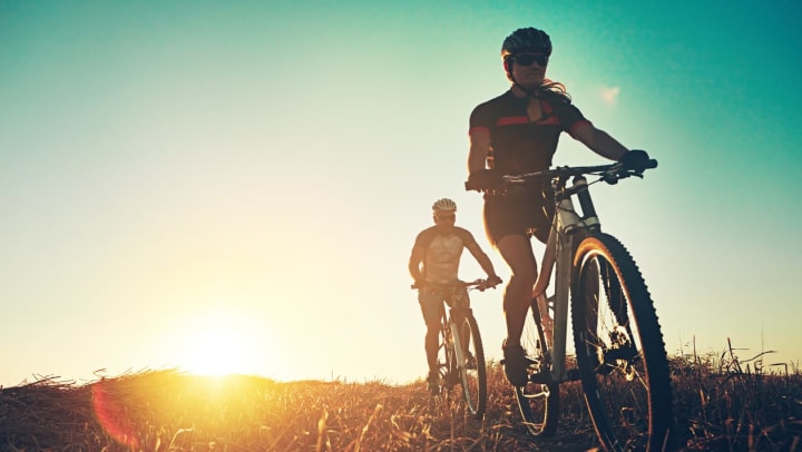 Two cyclists biking at sunset | Jacksonville bike shops