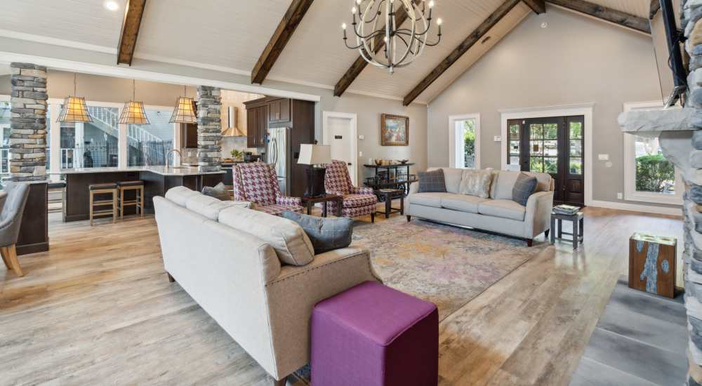 Interior of a clubhouse with fireplace, TV and connecting kitchen at Piccadilly Apartments in Goodlettsville, Tennessee