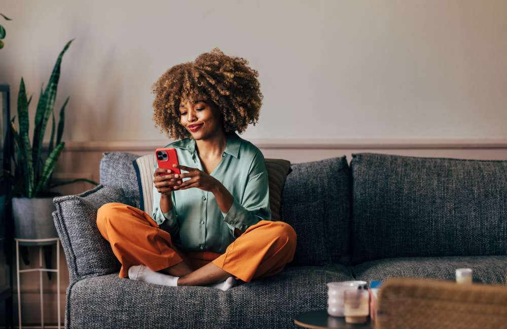 Resident sitting on a comfortable couch in a spacious living room at Lexington Green in El Cajon, California