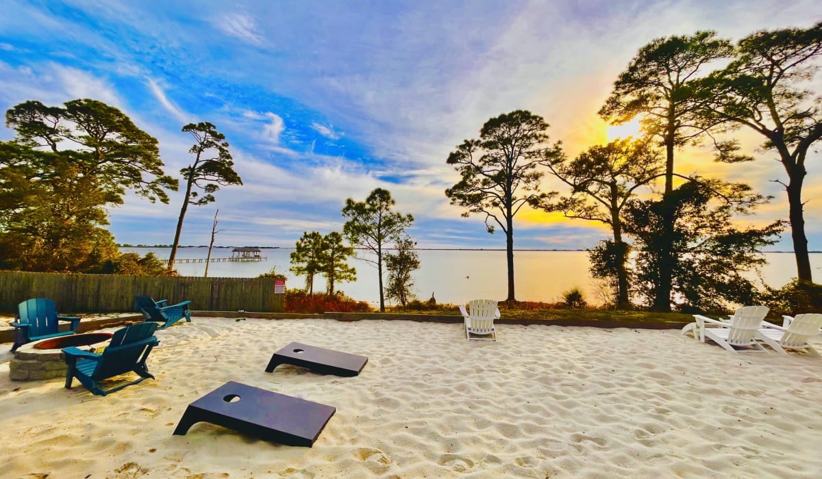 outdoor amenities with chair and cornhole game lot at Emerald Shores in Mary Esther, Florida