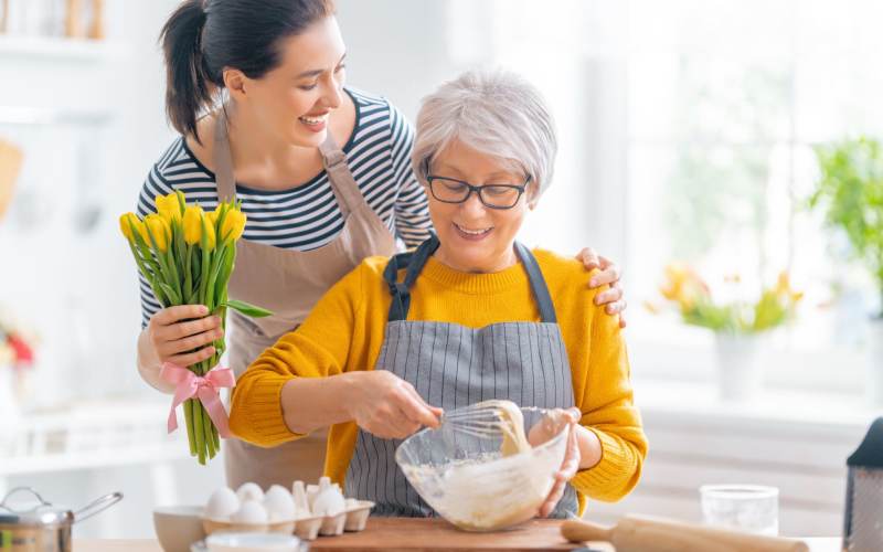 Happy resident mixing dough with her daughter at Silver Creek in St. Augustine, Florida