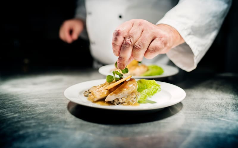 Chef applying a garnish at Blossom Collection in Rochester, Michigan