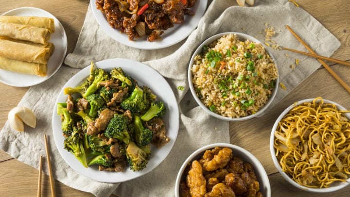 A variety of Chinese dishes served in bowls on a wood table at a restaurant in Keller.