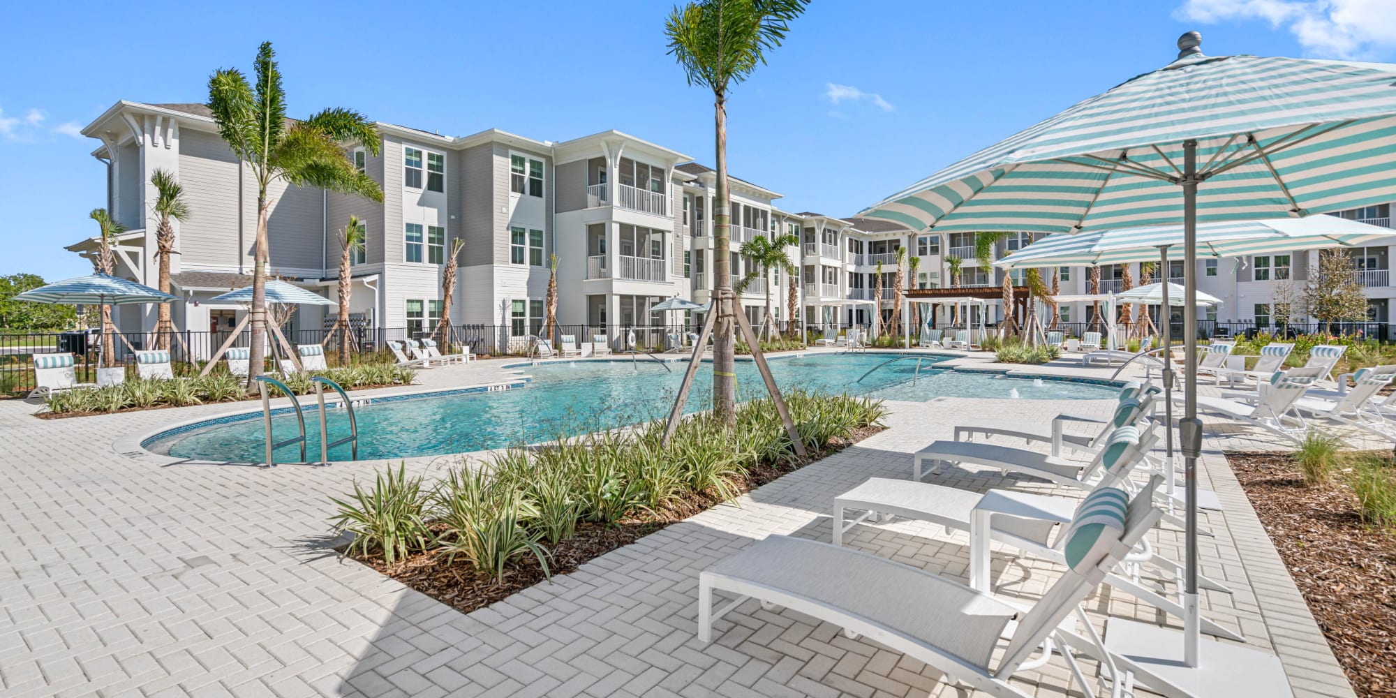 Sparkling resort-style swimming pool and poolside seating at The Griffon Vero Beach | Apartments in Vero Beach, Florida