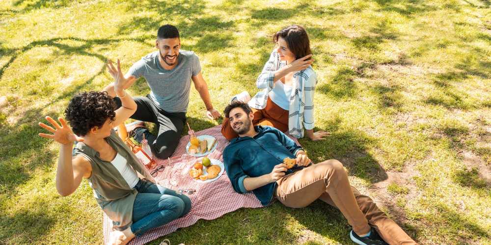 A group of friends relaxing in a park near The Oliver in Charlotte, North Carolina