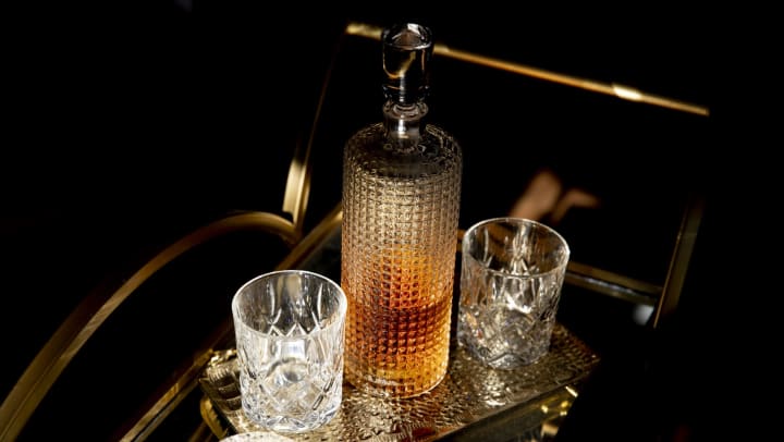 whiskey and two glasses on a bar cart | tips for setting up a bar cart 