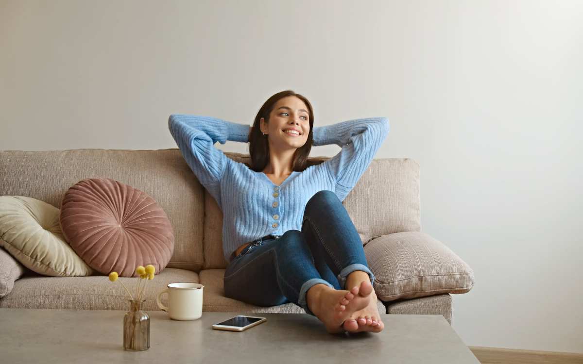Resident sitting on couch in her apartment at Tyndall Pointe in Panama City, Florida