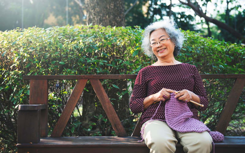 Resident knitting outdoors at Grand Villa of Palm Coast in Palm Coast, Florida