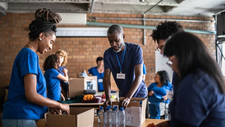 A group of volunteers fill boxes with supplies | volunteering in Phoenix