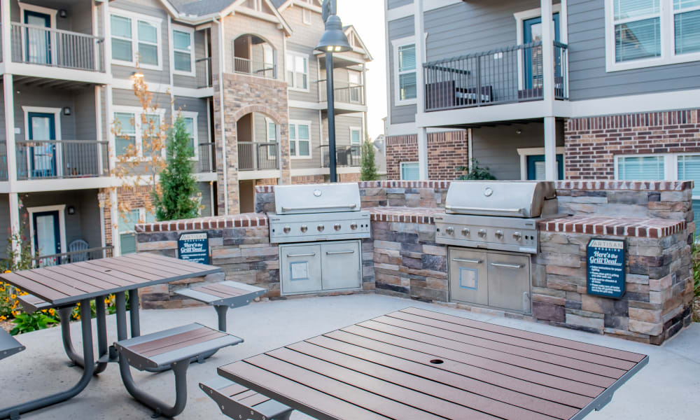 Grilling area next to pool with tables to use at 24Hundred Apartments in Oklahoma City, Oklahoma