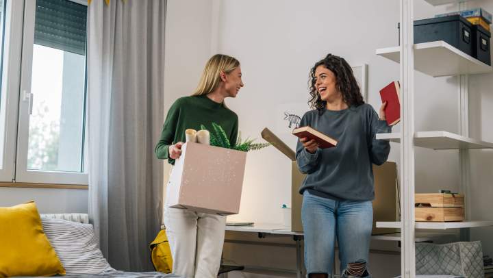 Two women moving into their dorm room and organizing