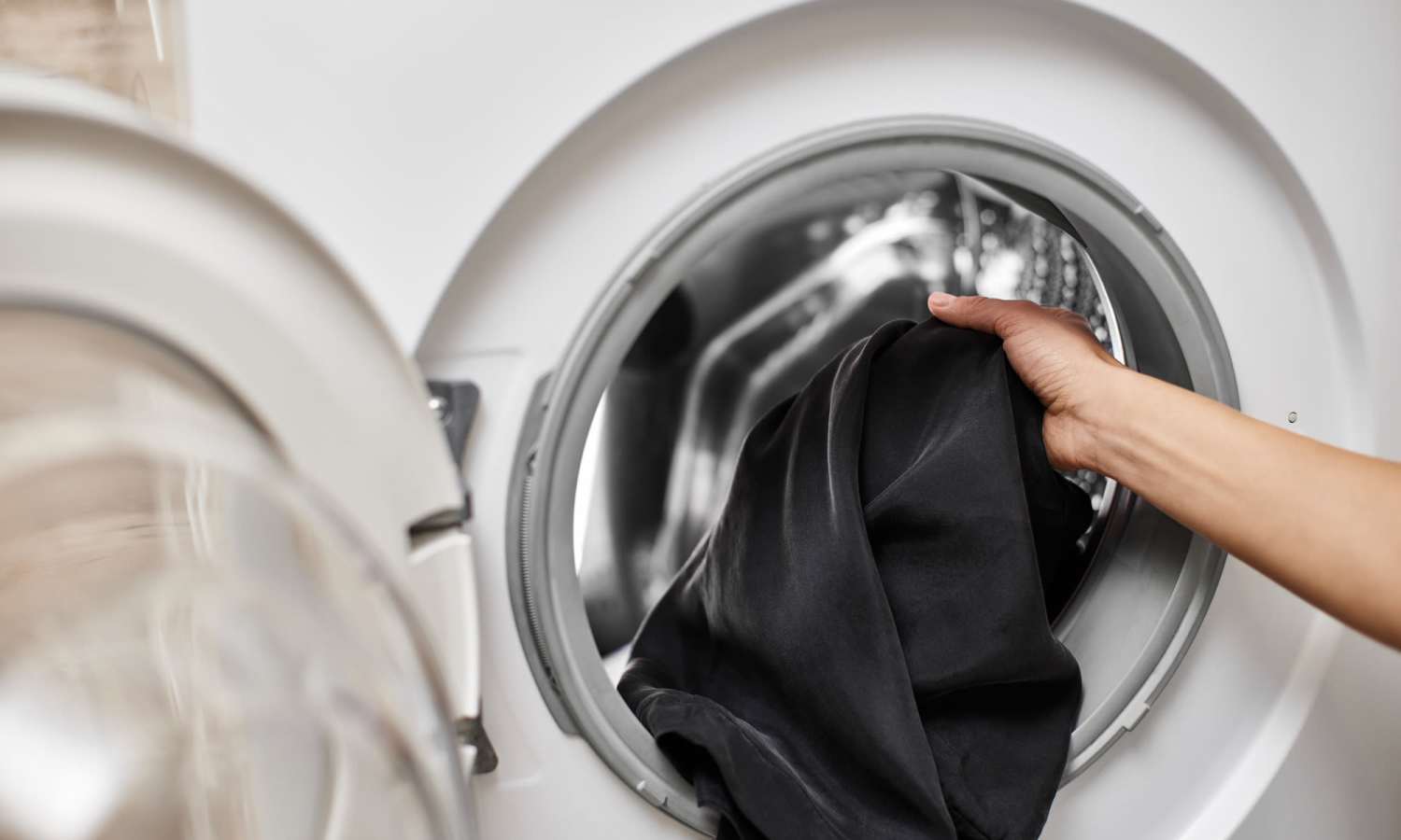 Resident using washing machine at her apartment home at Pecan Villa Apartments in Houston, Texas