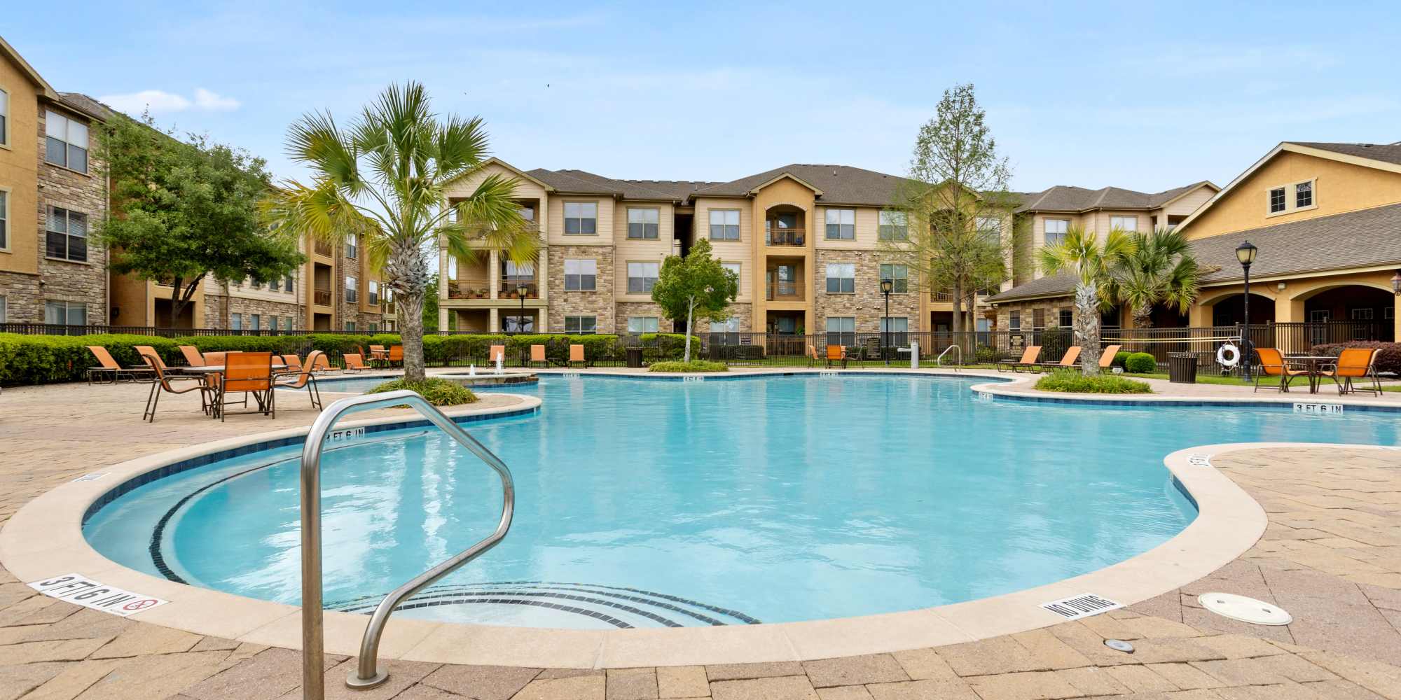Sparkling swimming pool with sun deck, lounge chairs and access to clubhouse at Park Avenue at Boulder Creek in Houston, Texas