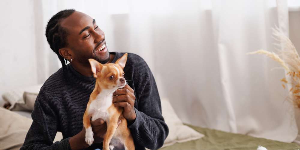 Resident holding his pup in their new home at Evergreen Westside in Gainesville, Florida