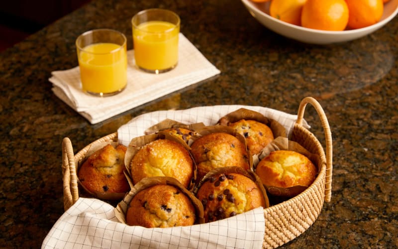 Basket of muffins next to a couple glasses of orange juice on a counter at Amira Choice Forest Lake in Forest Lake, Minnesota