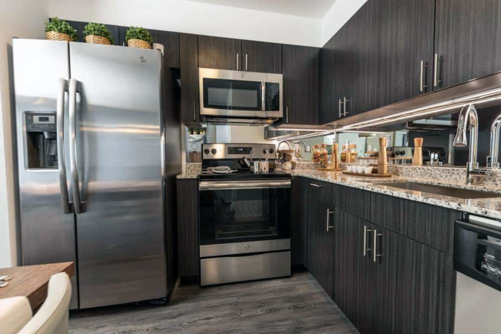Dark kitchen cabinets with stainless-steel appliances at Sophia Square in Homestead, Florida