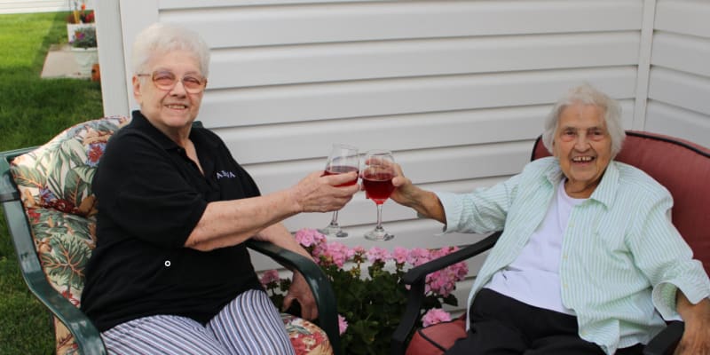 Two residents toasting and smiling at Garden Place Senior Living