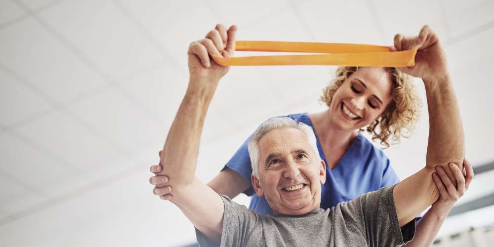 A staff member helping a resident stretch at Careage at Home in Bellevue, Washington. 