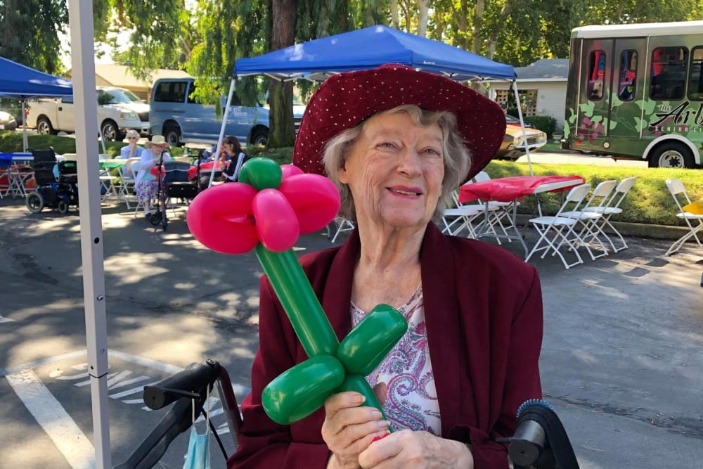 Resident holding a balloon rose at an event at Lodi Commons Senior Living in Lodi, California
