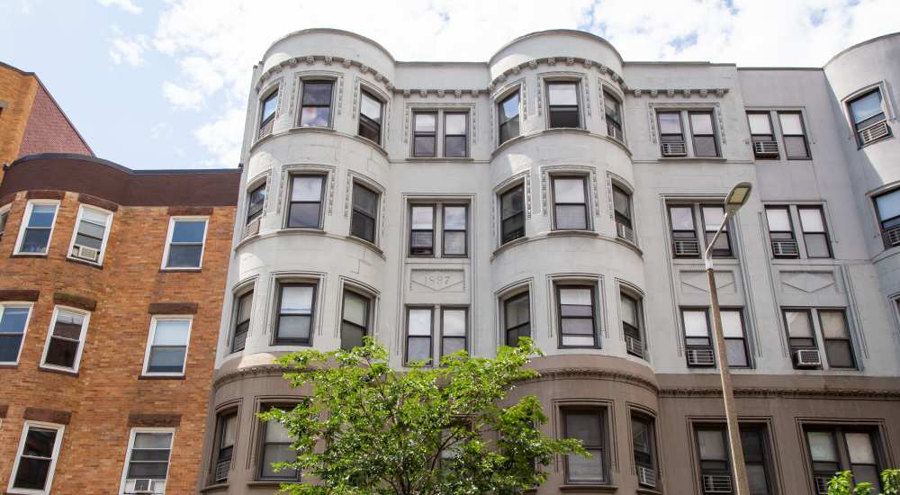 Tree branches partially cover building facade at 15-25 Hemenway Apartments in Boston, Massachusetts