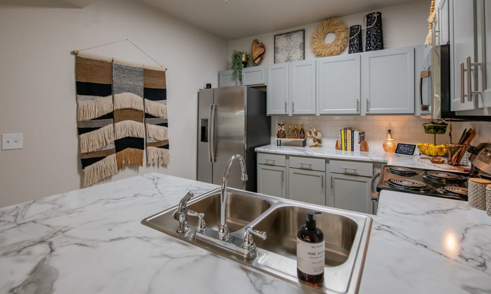 Spacious kitchen with granite countertops and light cabinetry at Redbud Ranch Apartments in Broken Arrow, Oklahoma