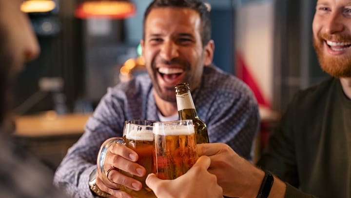 Friends clinking beer beers together at a pub in Tampa