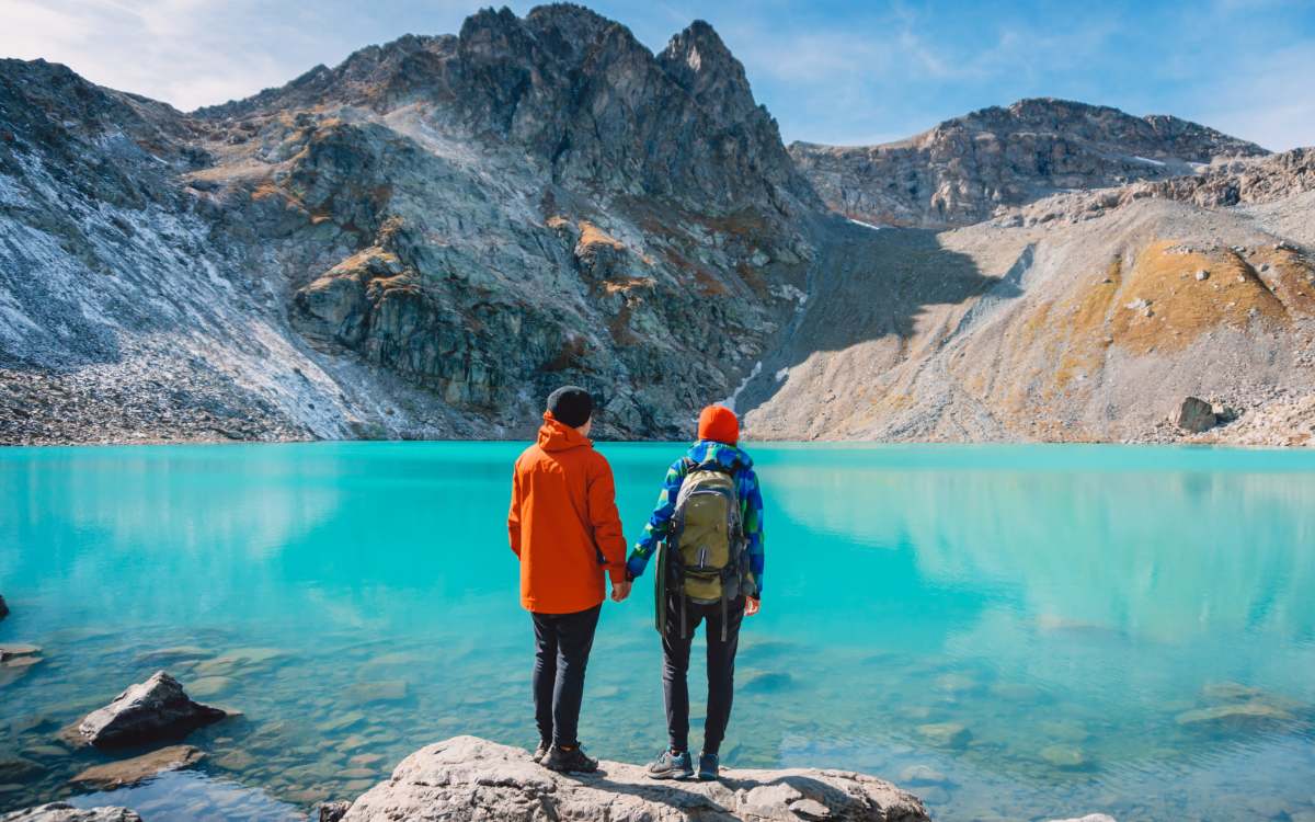 A couple holding hands stands and looking out at the rocky mountains near Franklin Manor Apartments in Saint Helens, Oregon