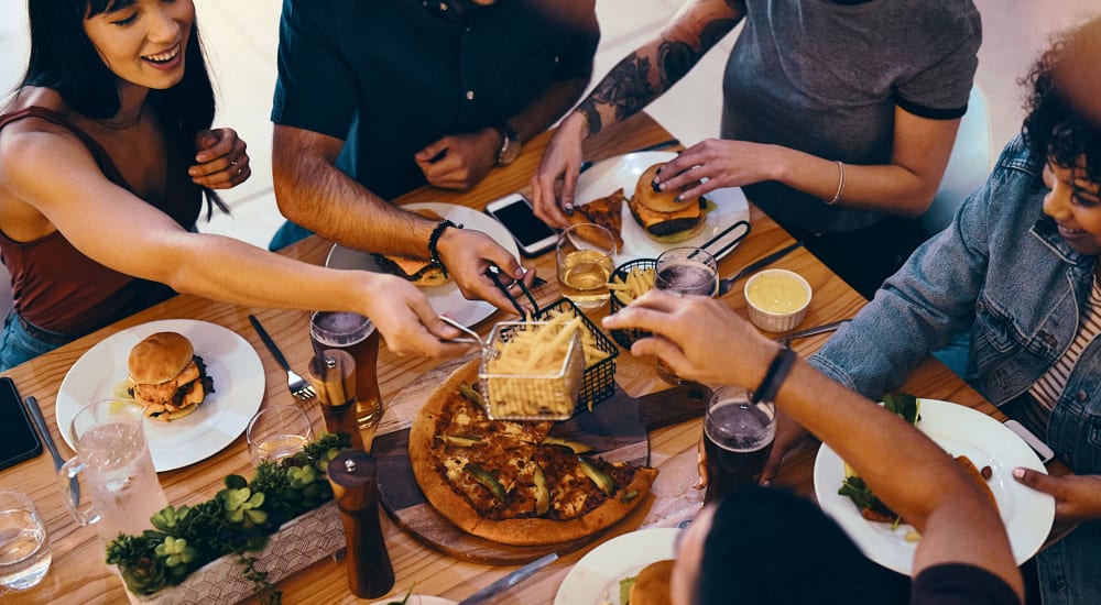 A group of people sharing food in a restaurant near Residences at Congressional Village in Rockville, Maryland