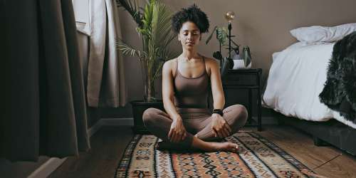 Resident practicing yoga in a spacious bedroom at Kernwood Terrace in Los Angeles, California