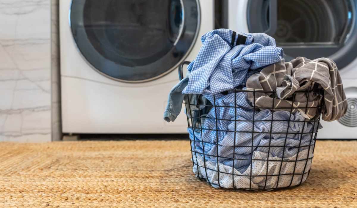 Laundry basket of clothes next to a washer and dryer atWestwood in Jackson, Mississippi