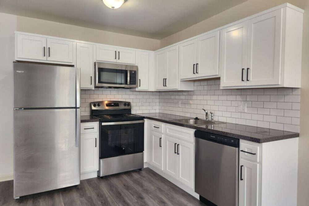 Upgraded kitchen with white cabinets, stainless appliances