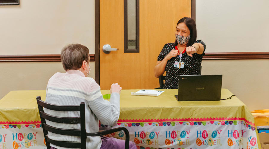 Loved one showing photos of our community to a prospective adult day health resident at Peoples Senior Living in Tacoma, Washington