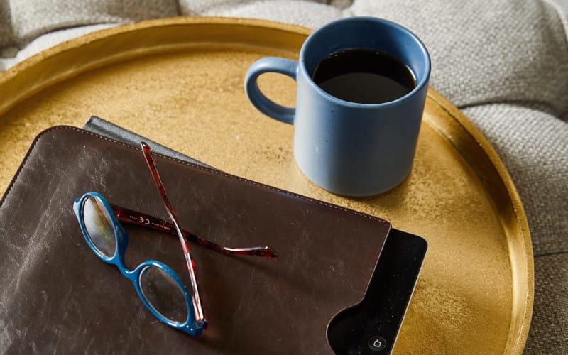 Tray with leather folder, eyeglasses and a coffee mug at Amira Choice Bloomington in Bloomington, Minnesota