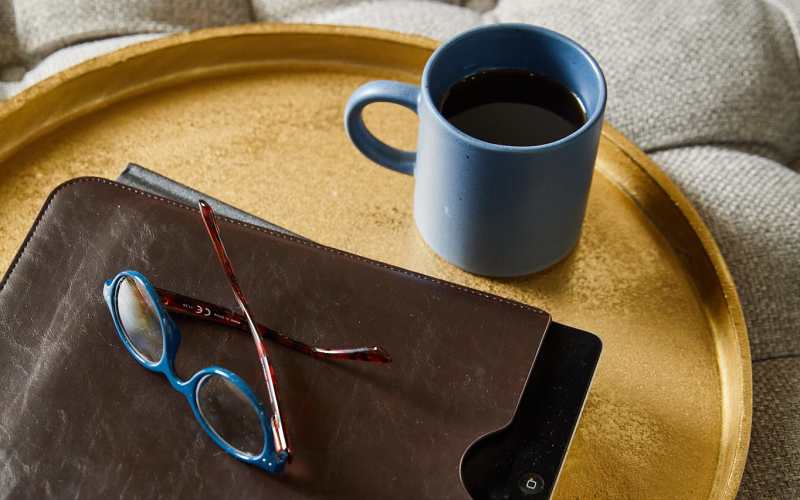 Tray with leather folder, eyeglasses and a coffee mug at SL Location 2 in Bend, Oregon