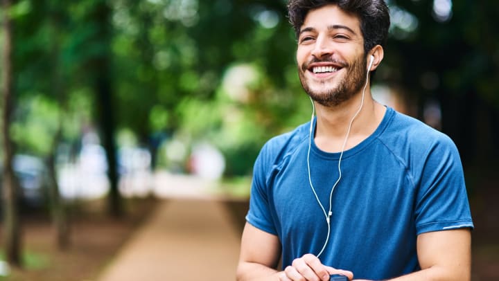 Man smiling in the park after running