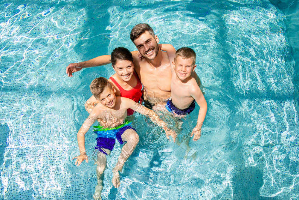 Resident enjoying with family in pool at Boomer Creek Apartments in Stillwater, Oklahoma