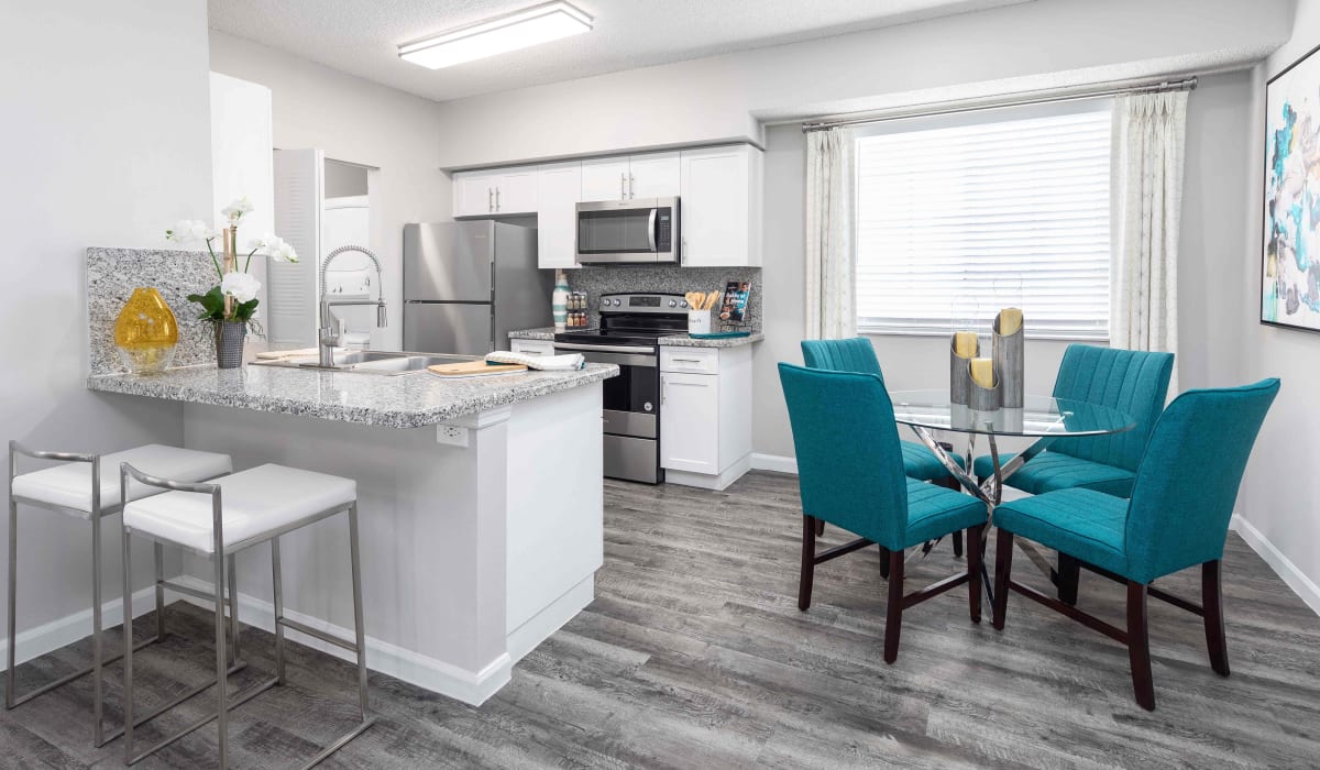 Fully equipped contemporary kitchen and dining area of a model apartment home at Nova Central Apartments in Davie, Florida