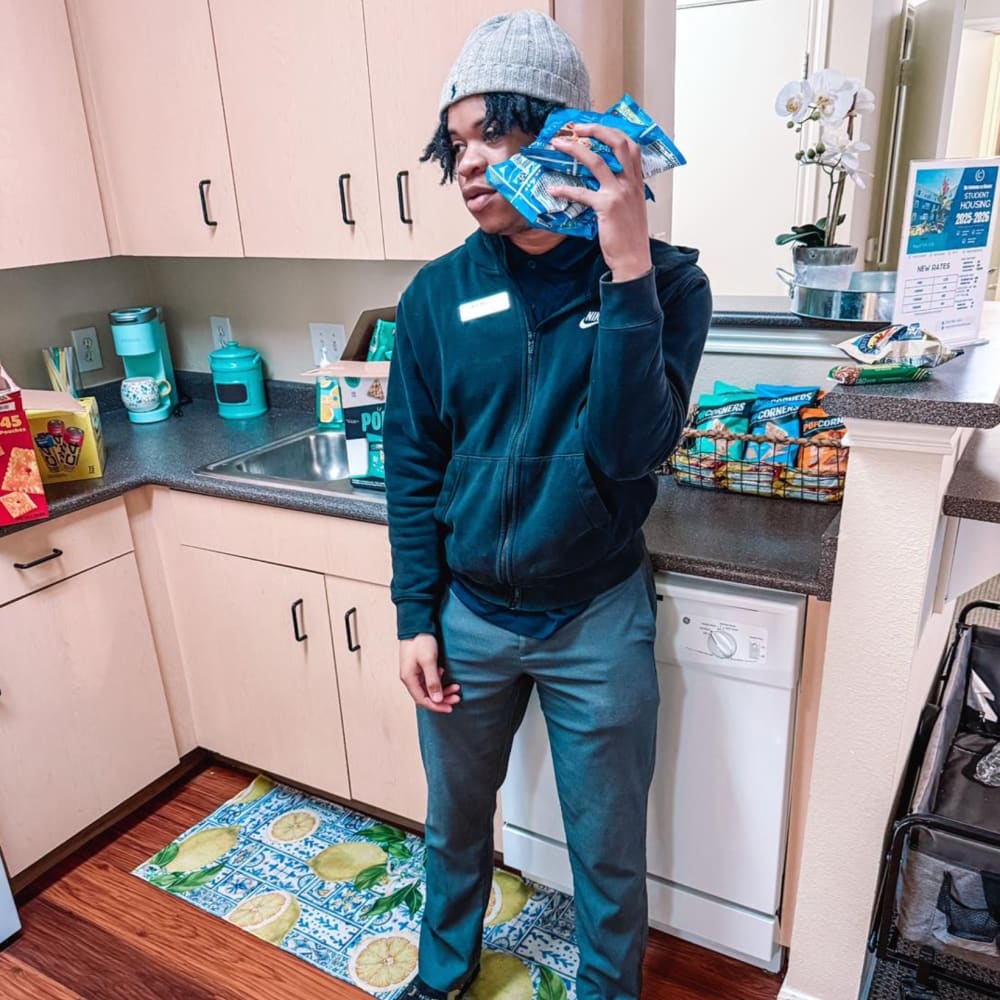 Resident holding bags of chips at Commons on Kinnear in Columbus, Ohio