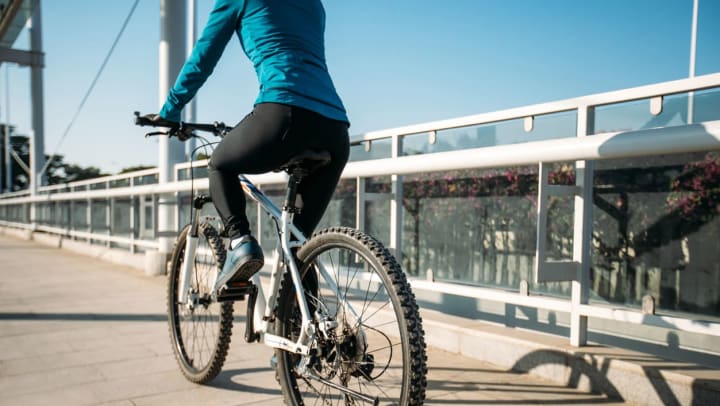 Woman riding a bike around the city on a sunny day.