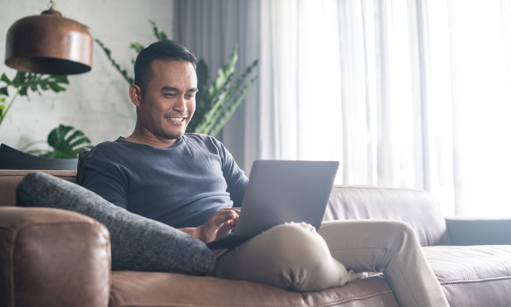 Happy resident checking out our online resources from his new apartment at Stone Ranch Townhomes in Seguin, Texas