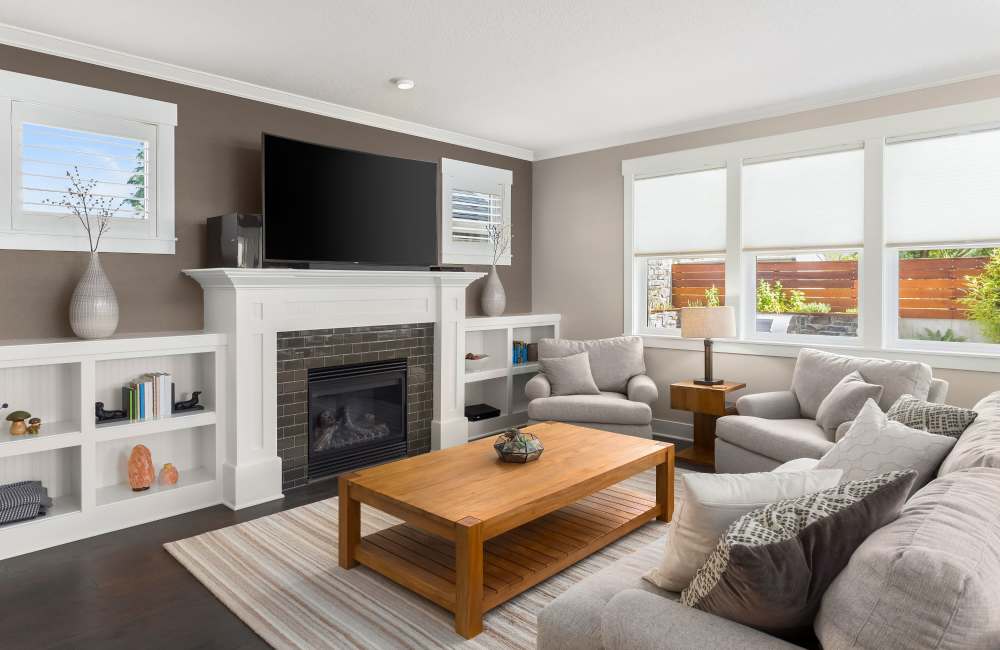 Cozy living room with modern furniture, fireplace and white cabinetry at Whispering Woods in Modesto, California